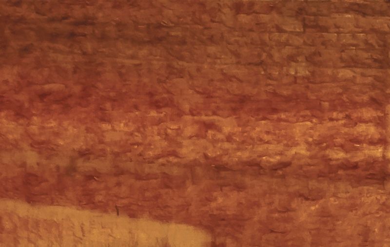 A close up of a brown wall with a brick texture.