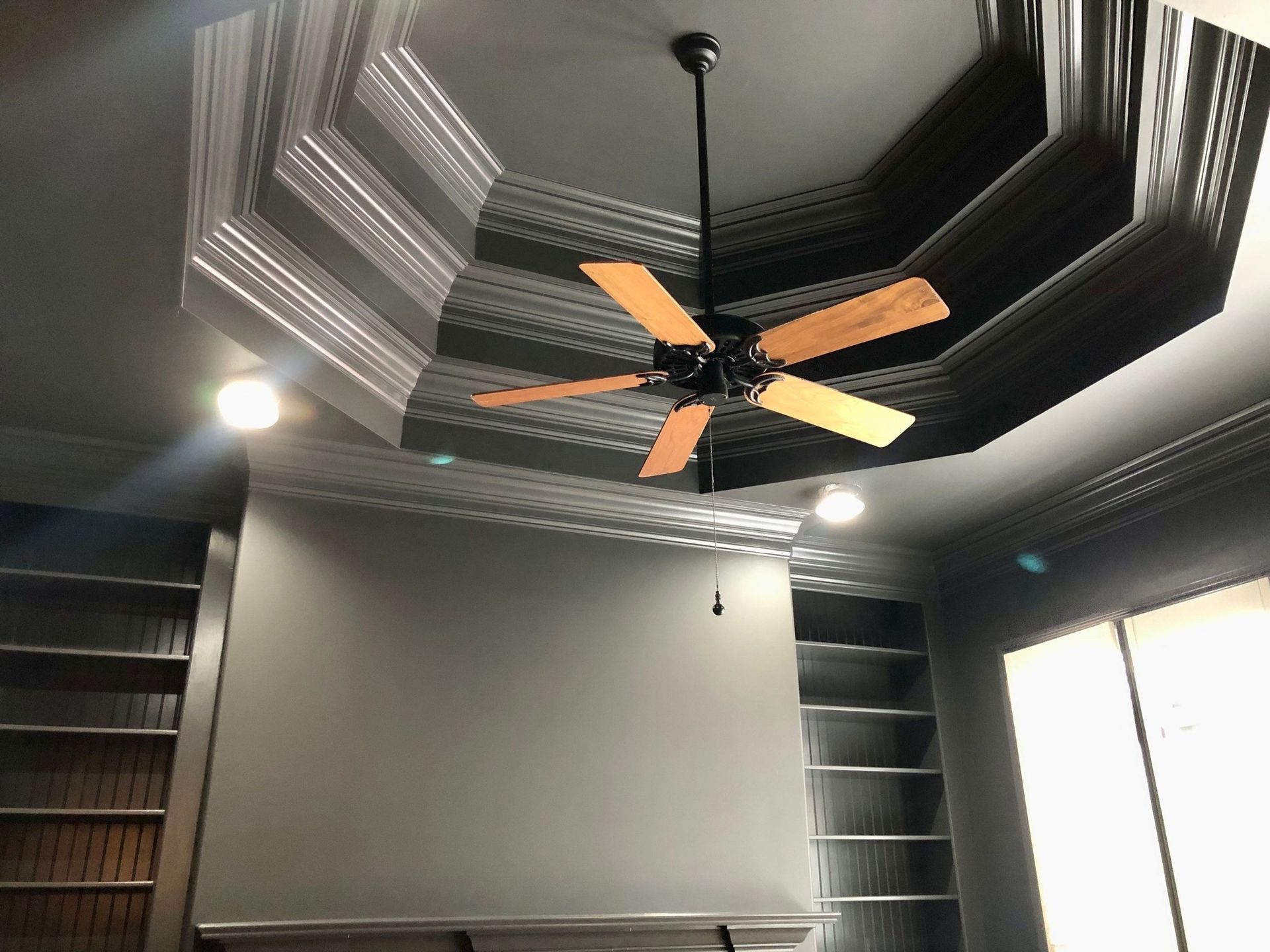 A ceiling fan is hanging from the ceiling of a room.