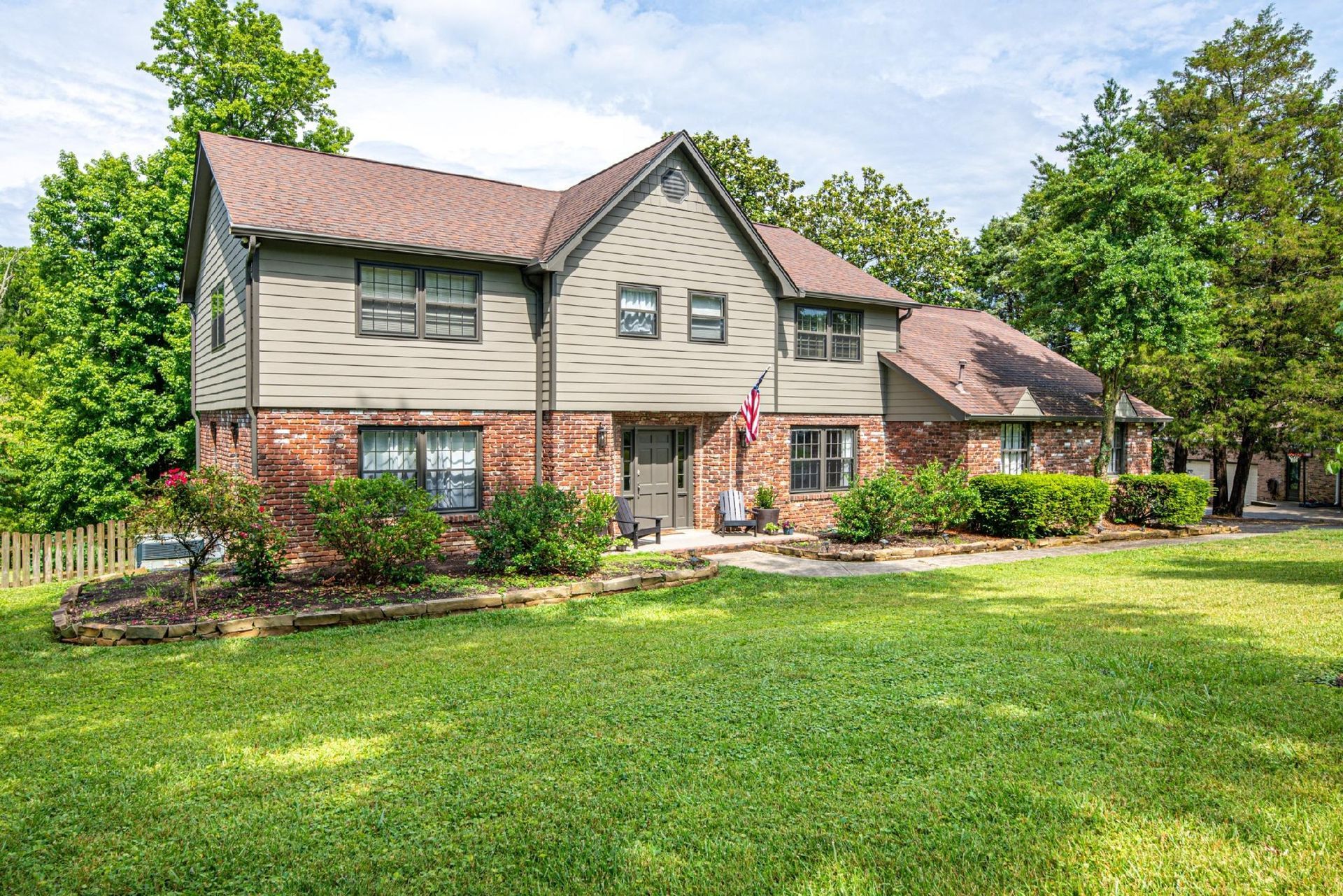 A large brick house with a large lawn in front of it.