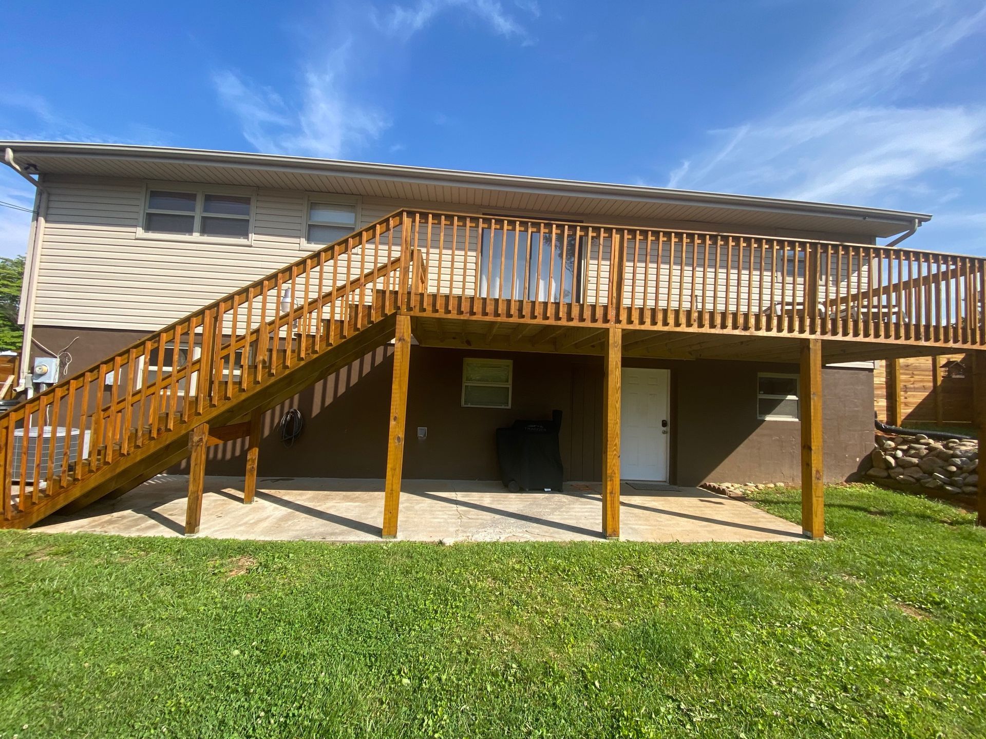 A house with a large deck and stairs leading up to it.