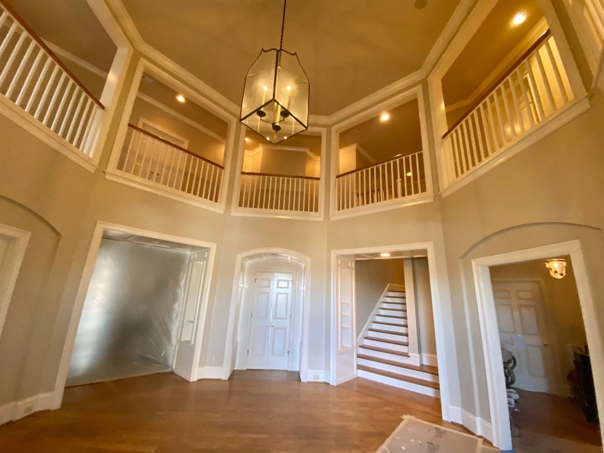 a large room with stairs and a chandelier hanging from the ceiling .