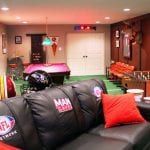 A living room with a pool table and a couch.