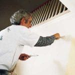 pro-paint-secrets-02 A man is painting a wall with a brush.