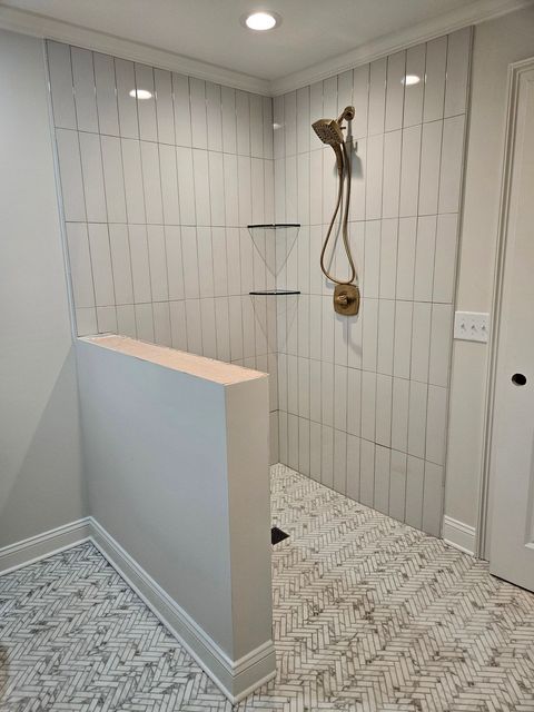 A bathroom with a walk in shower and a shower head.