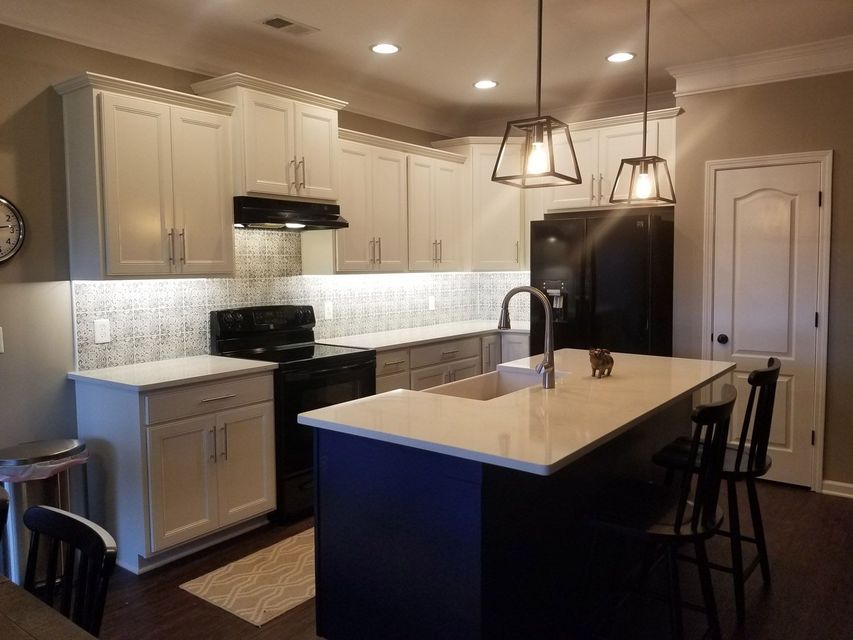 A kitchen with white cabinets and a blue island