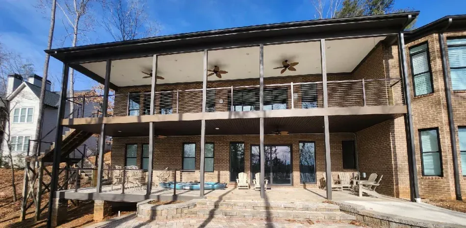 A large brick house with a balcony and stairs.