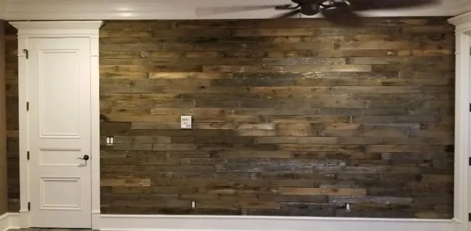 A room with a wooden wall and a ceiling fan.