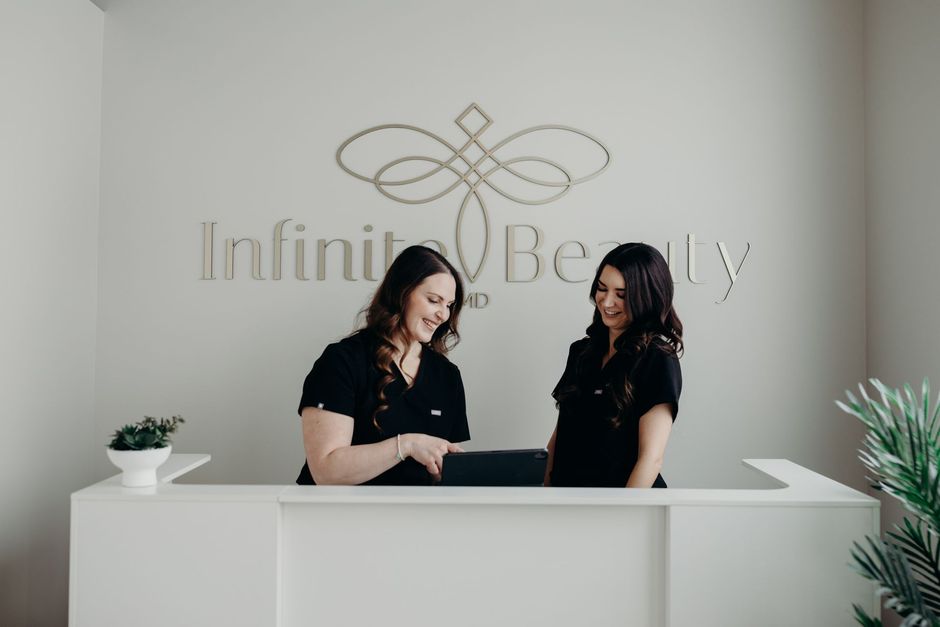 Two women are standing at a reception desk in a beauty salon.