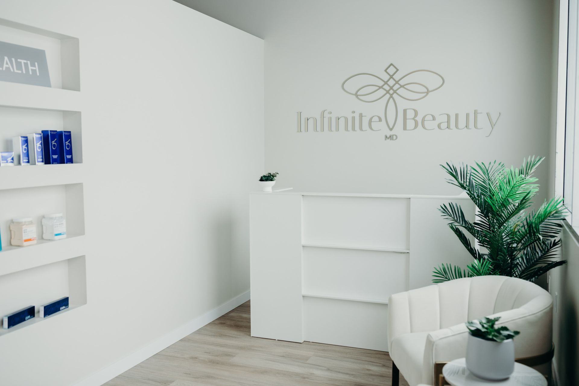 A white room with a chair and a sign that says `` infinite beauty '' on the wall.