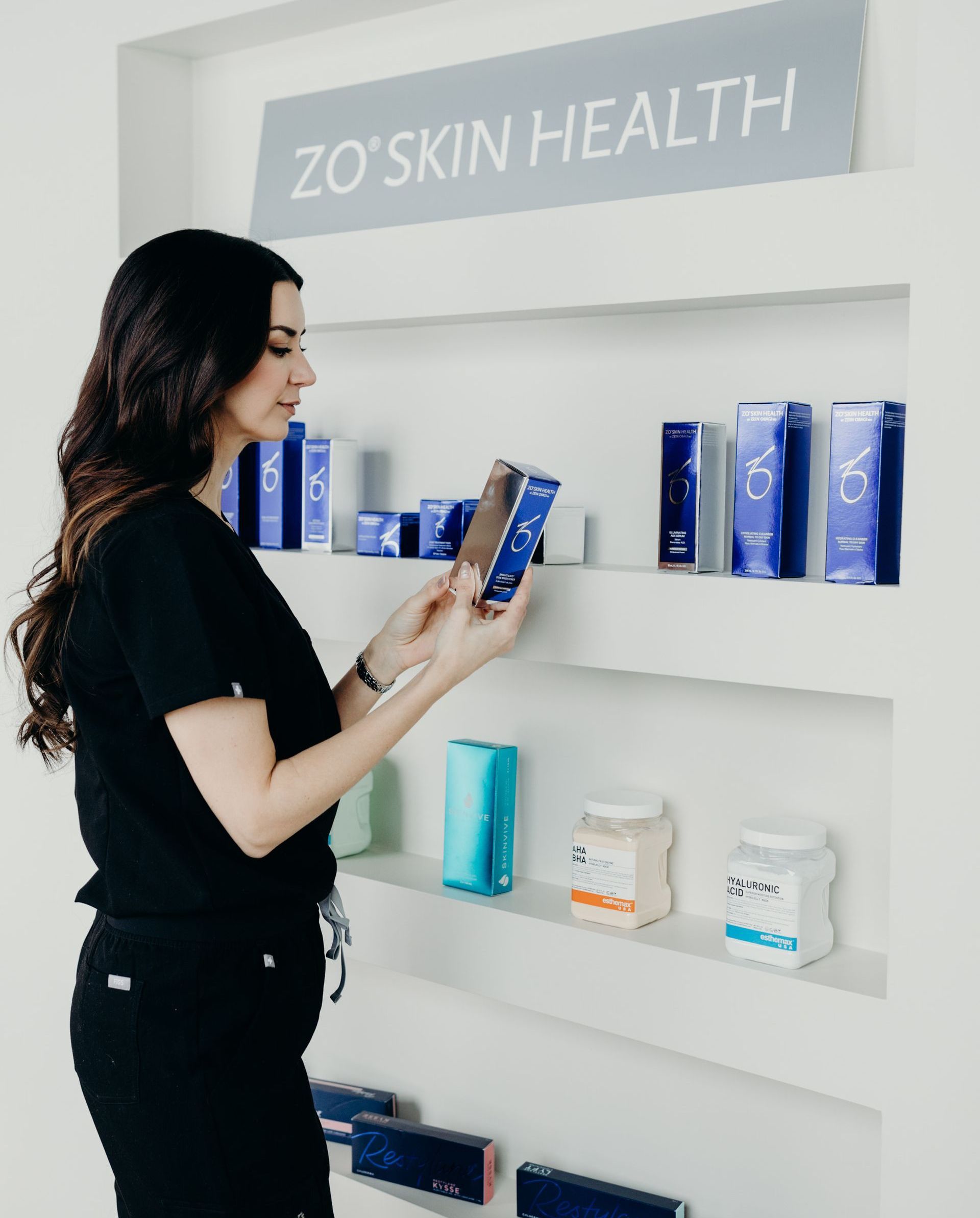 A woman is looking at a box of cosmetics on a shelf.