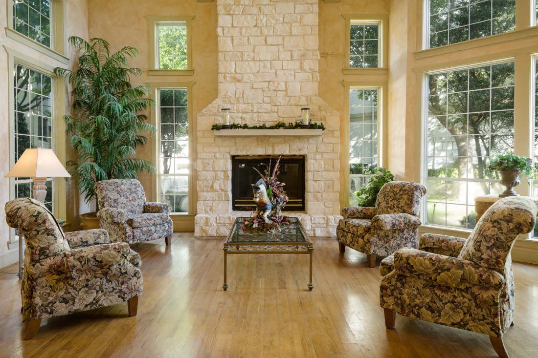 Cozy lounge area with floral chairs and a stone fireplace