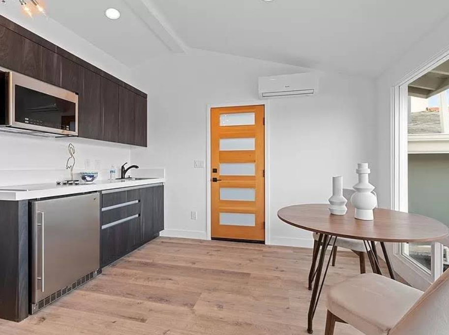 Minimalist kitchen and dining space with ladder style shelving.
