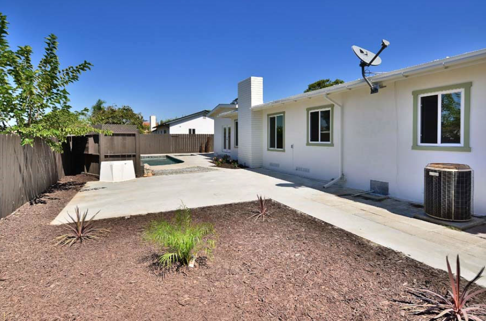 Modern home exterior with clean white walls and minimalist landscaping.