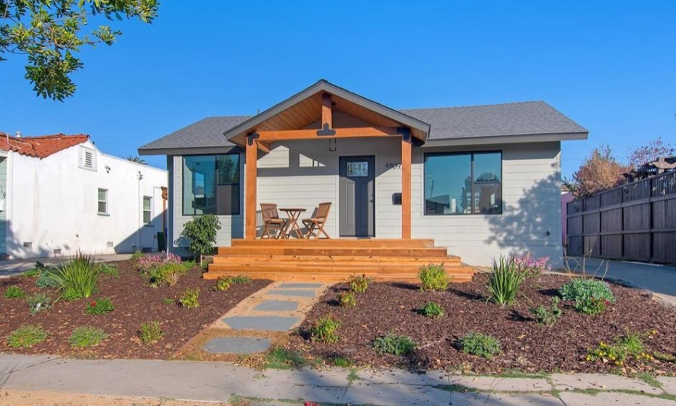 Backyard view of luxury house with landscaped garden and patio.