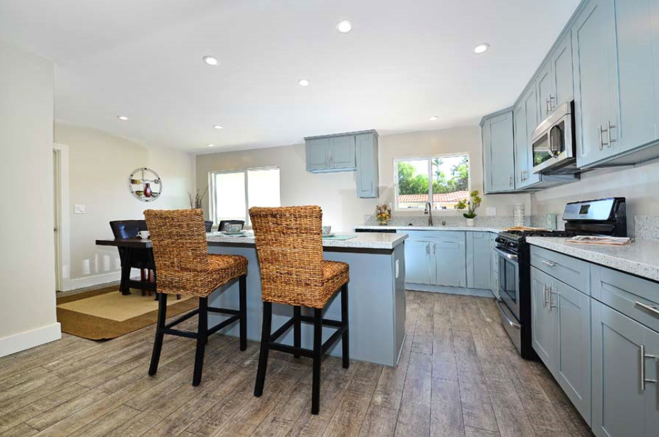 Kitchen and dining space with wooden dining table and modern appliances.