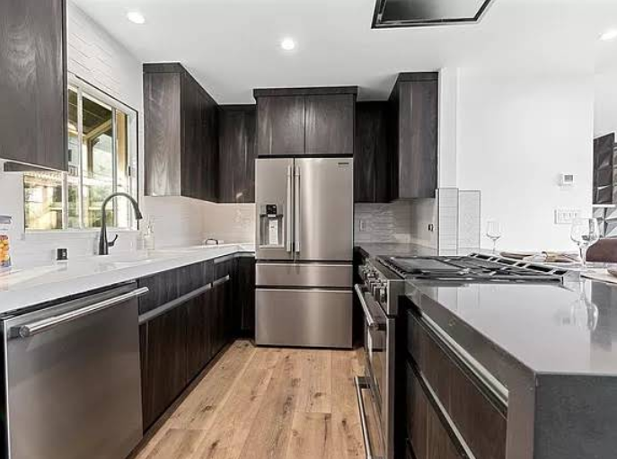 Contemporary kitchen interior with stainless steel appliances and dark cabinetry.