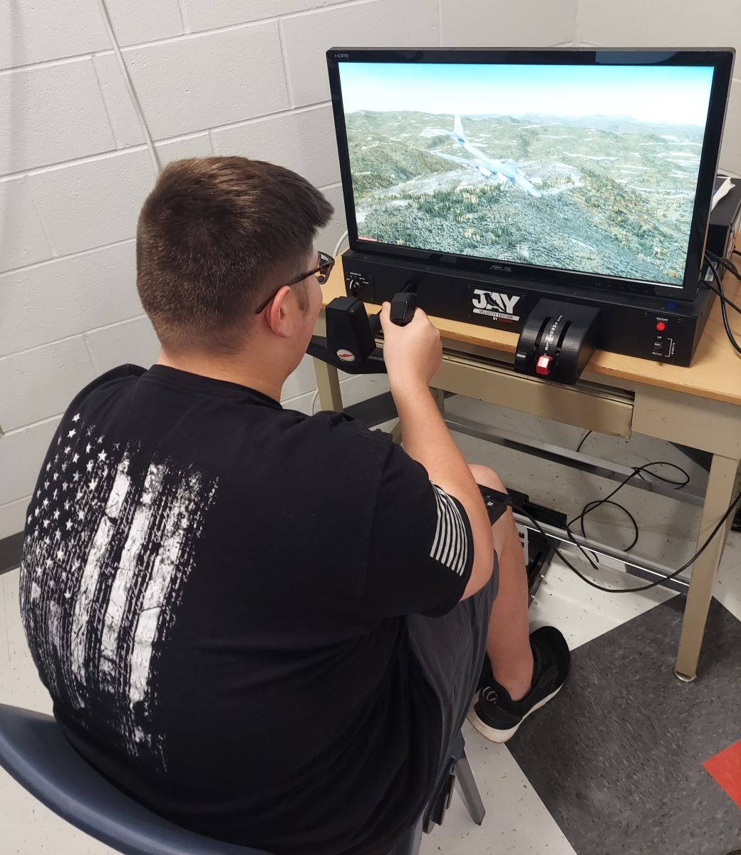 a man in a black shirt with an american flag on the back is playing a video game