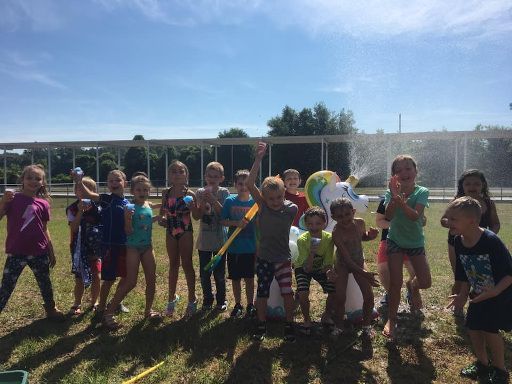 a group of children are standing next to each other in a field .