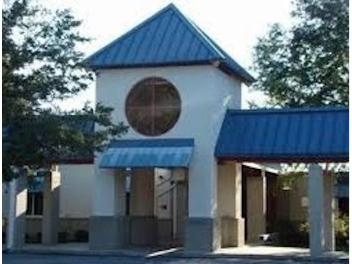 a white building with a blue roof and a round window .