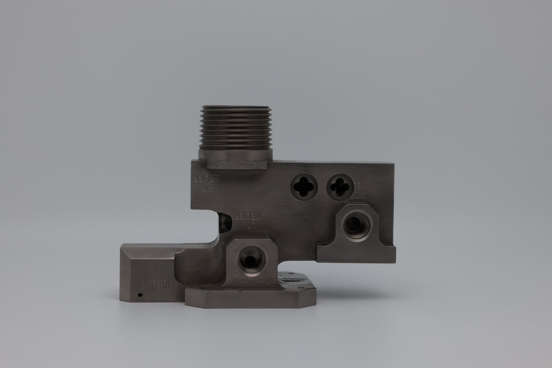 A close up of a metal piece on a white surface.