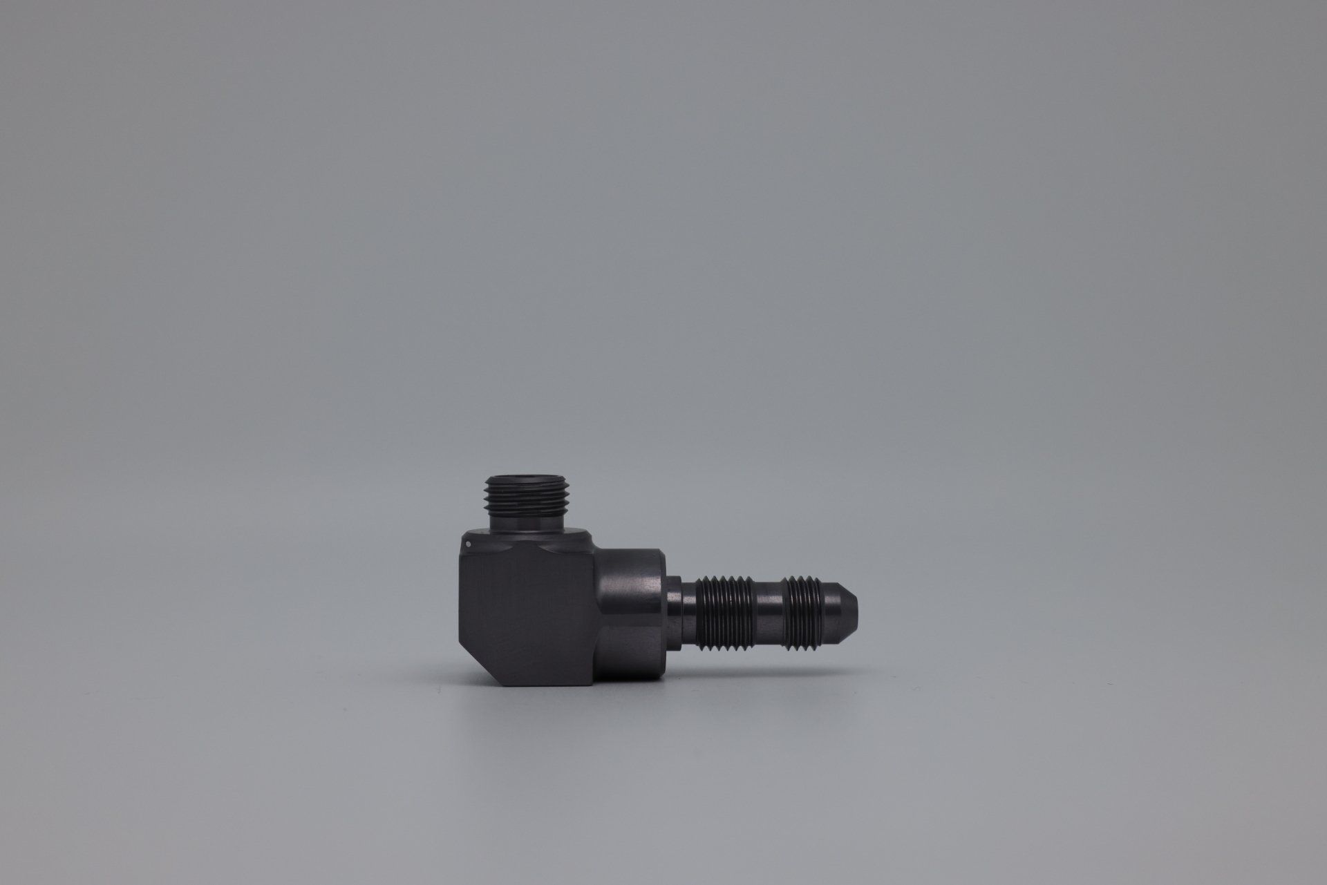 A small black object is sitting on a gray surface.