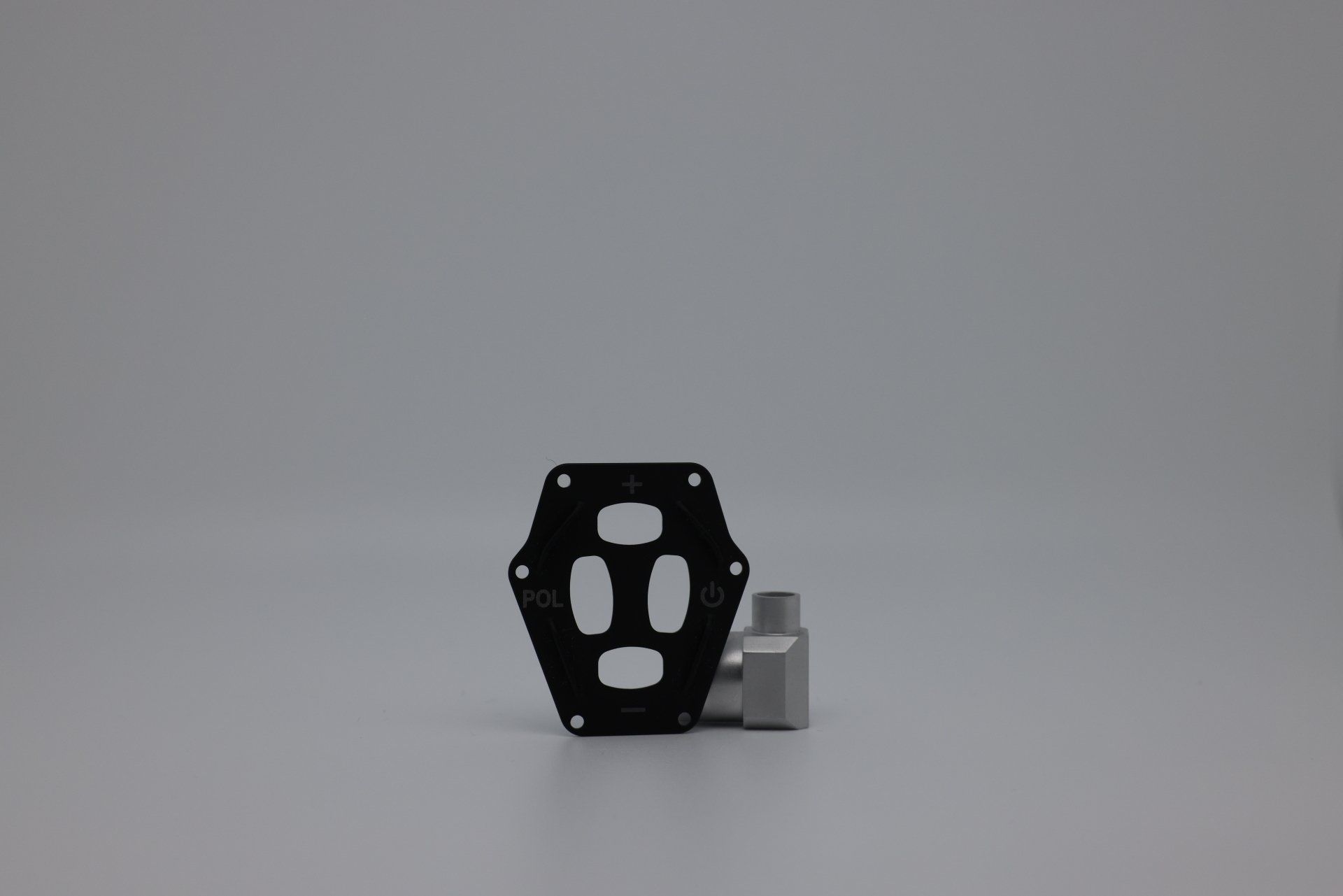 A black and silver object is sitting on a white surface.