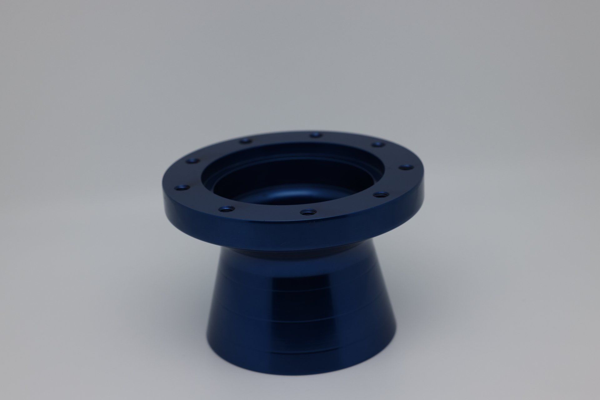 A blue object with holes in it is sitting on a white surface