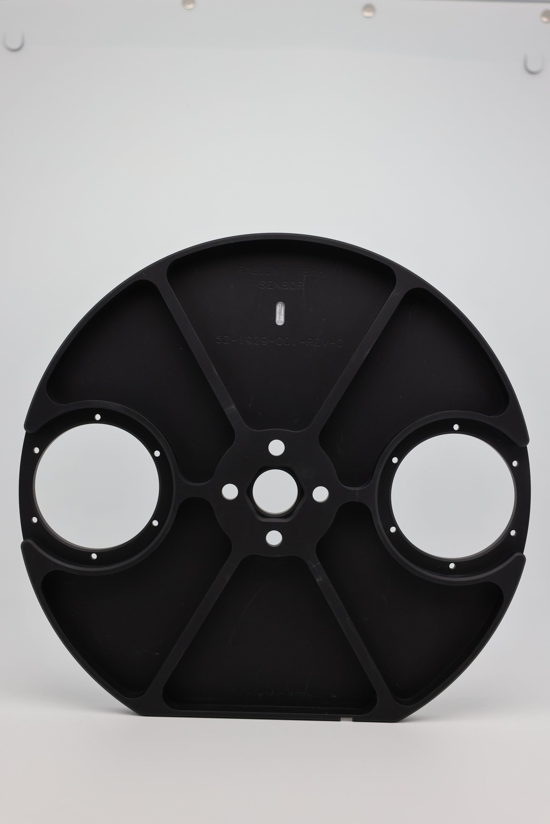 A black circular object with two holes in the middle