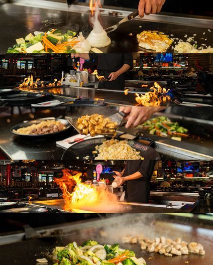 Japanese teppanyaki chef cooking vegetables and meat on a sizzling grill with flames