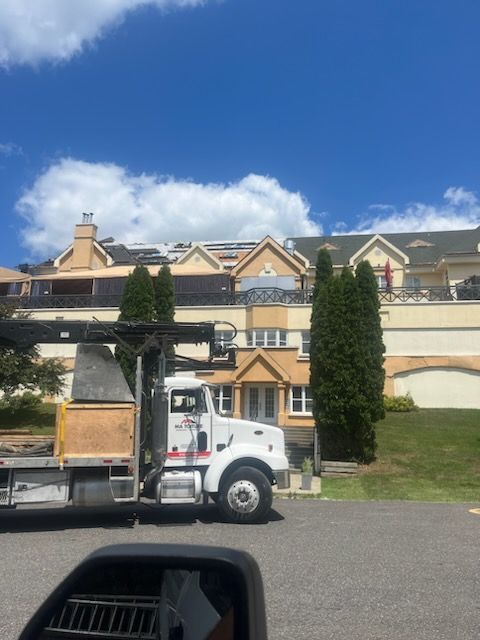 Un camion blanc est garé devant une grande maison