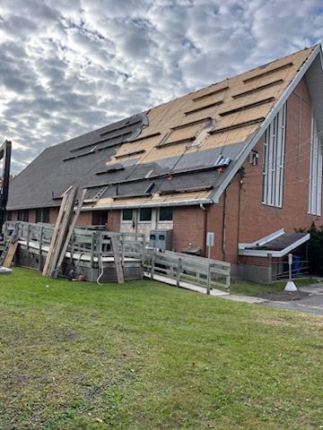 Un grand bâtiment en brique avec un toit en cours d installation.