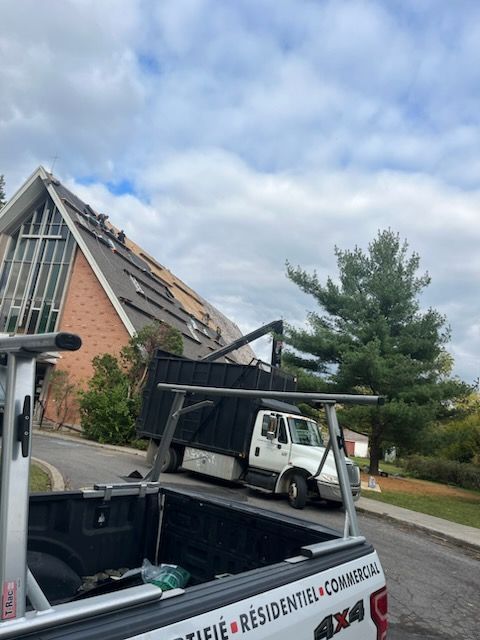 Un camion est garé au bord de la route, devant un immeuble en brique.