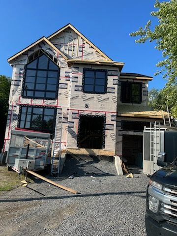 Une maison en construction avec un camion garé devant.