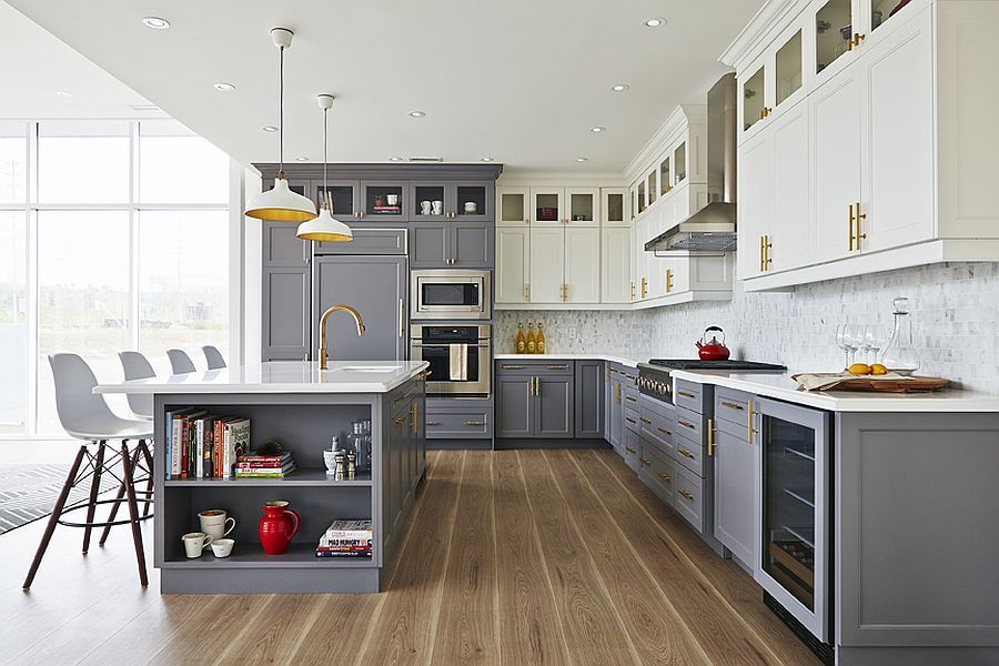A kitchen with gray cabinets , white cabinets , stainless steel appliances and a large island.