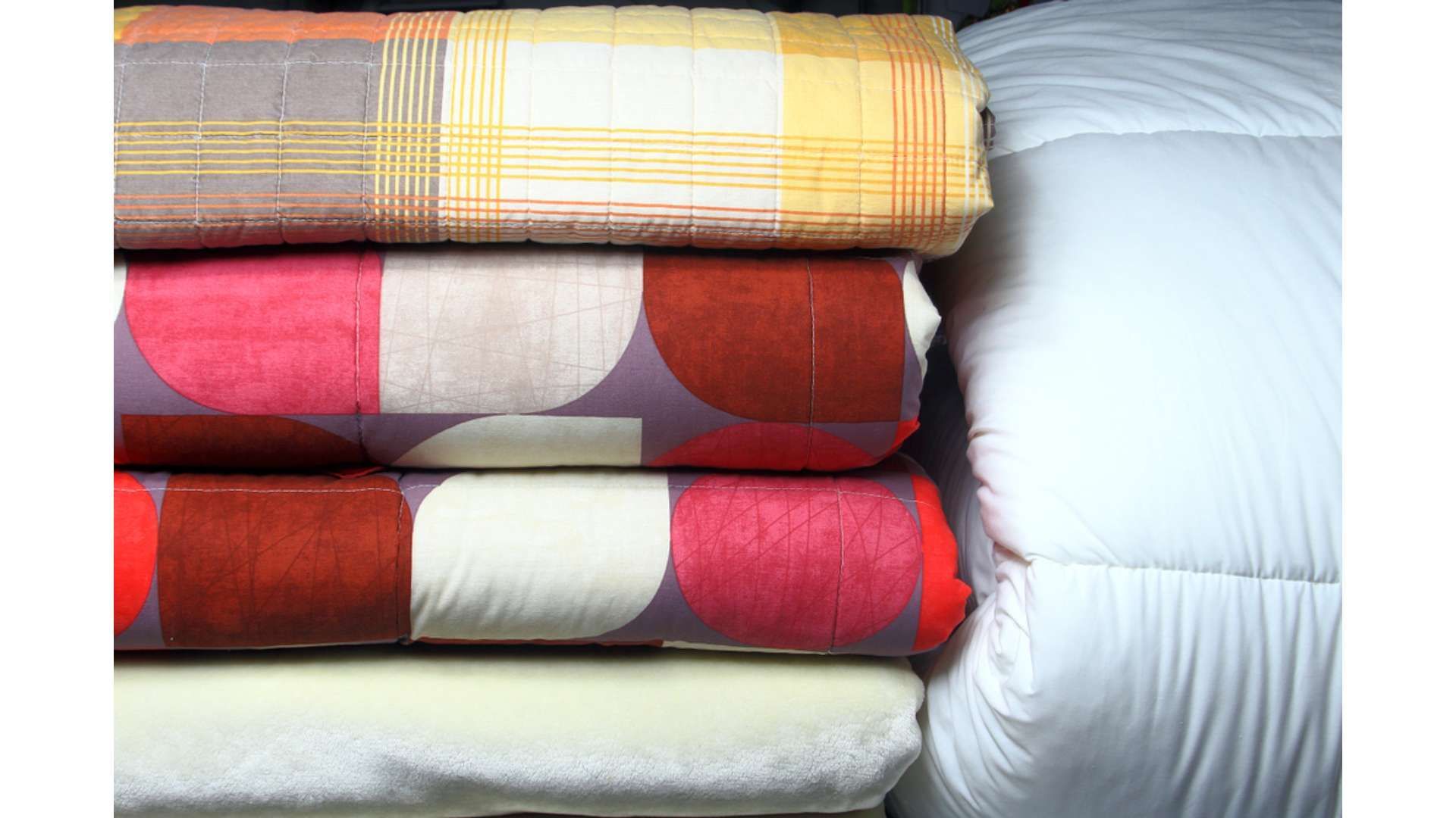 A Pile Of Blankets Stacked On Top Of Each Other On A Bed — Macquarie Dry Cleaners In Dubbo, NSW