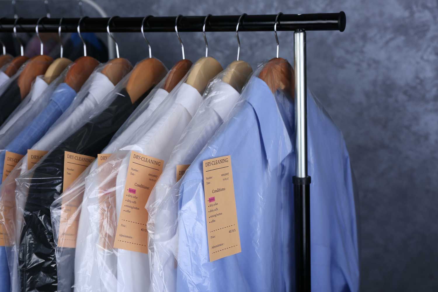 A Row Of Shirts Wrapped In Plastic Hang On A Rack — Macquarie Dry Cleaners In Dubbo, NSW