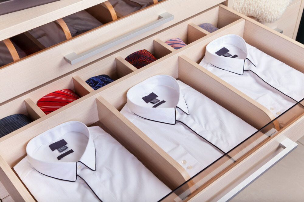A Row Of White Shirts Hanging On A Rack Against A White Brick Wall — Macquarie Dry Cleaners In Dubbo, NSW