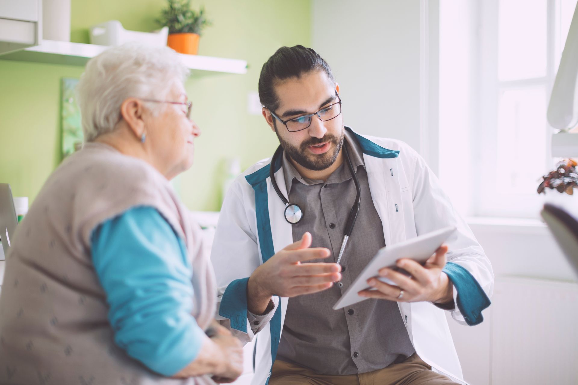 doctor showing a patient information on a HIPPA compliant tablet