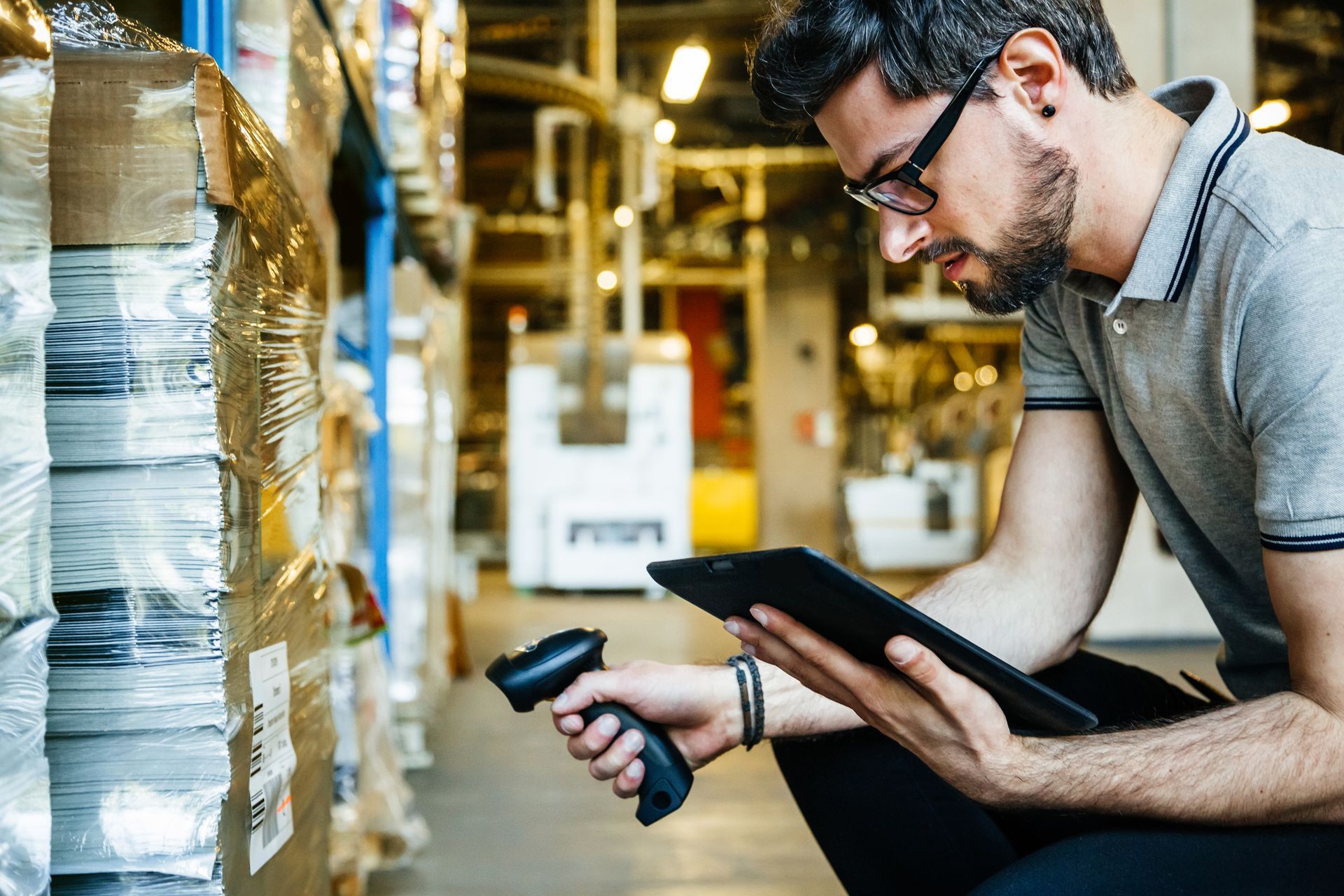 man doing inventory digitally in a manufacturing warehouse
