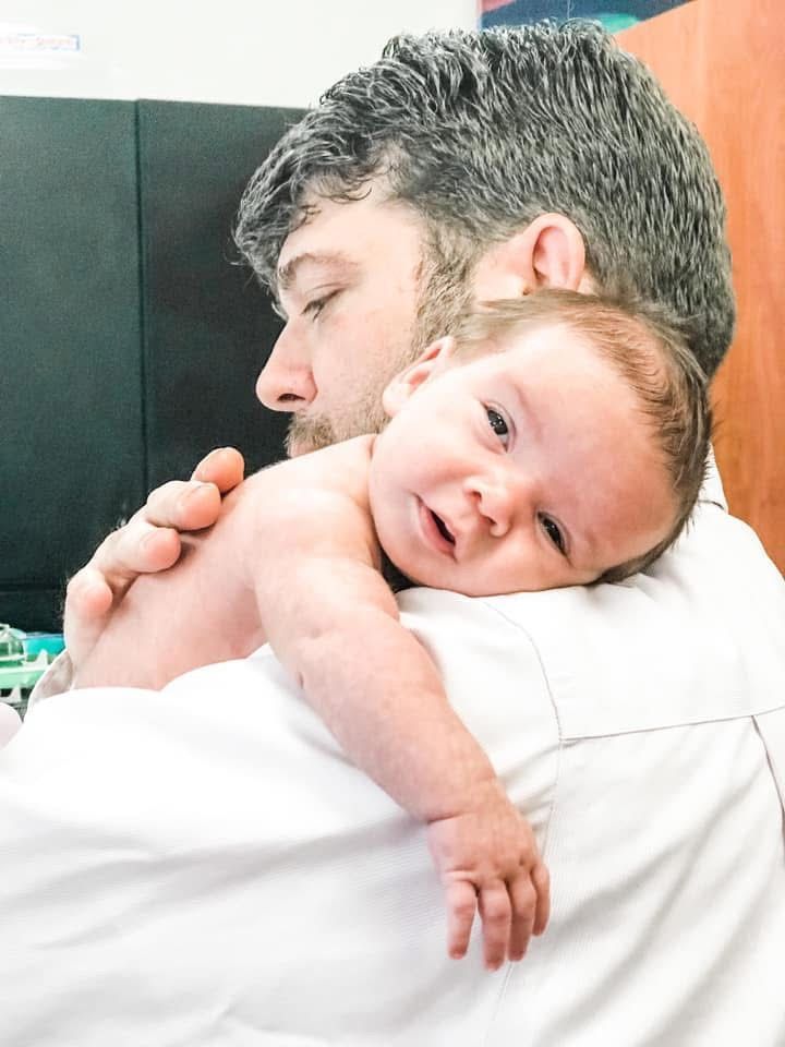 A man is holding a baby in his arms.