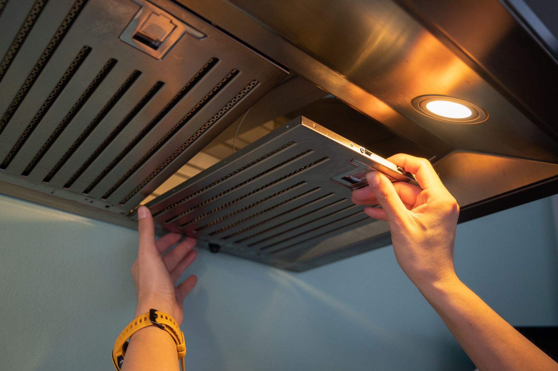 Woman hands trying to be removing filters from cooker