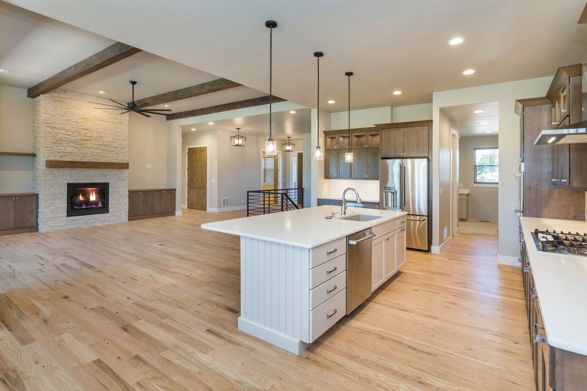 Spacious modern kitchen with island, stainless steel appliances, and fireplace.