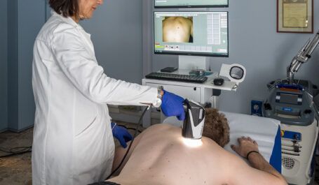 Procedura medica in ambulatorio: il medico utilizza una sonda ecografica su un paziente sdraiato sul lettino da visita.