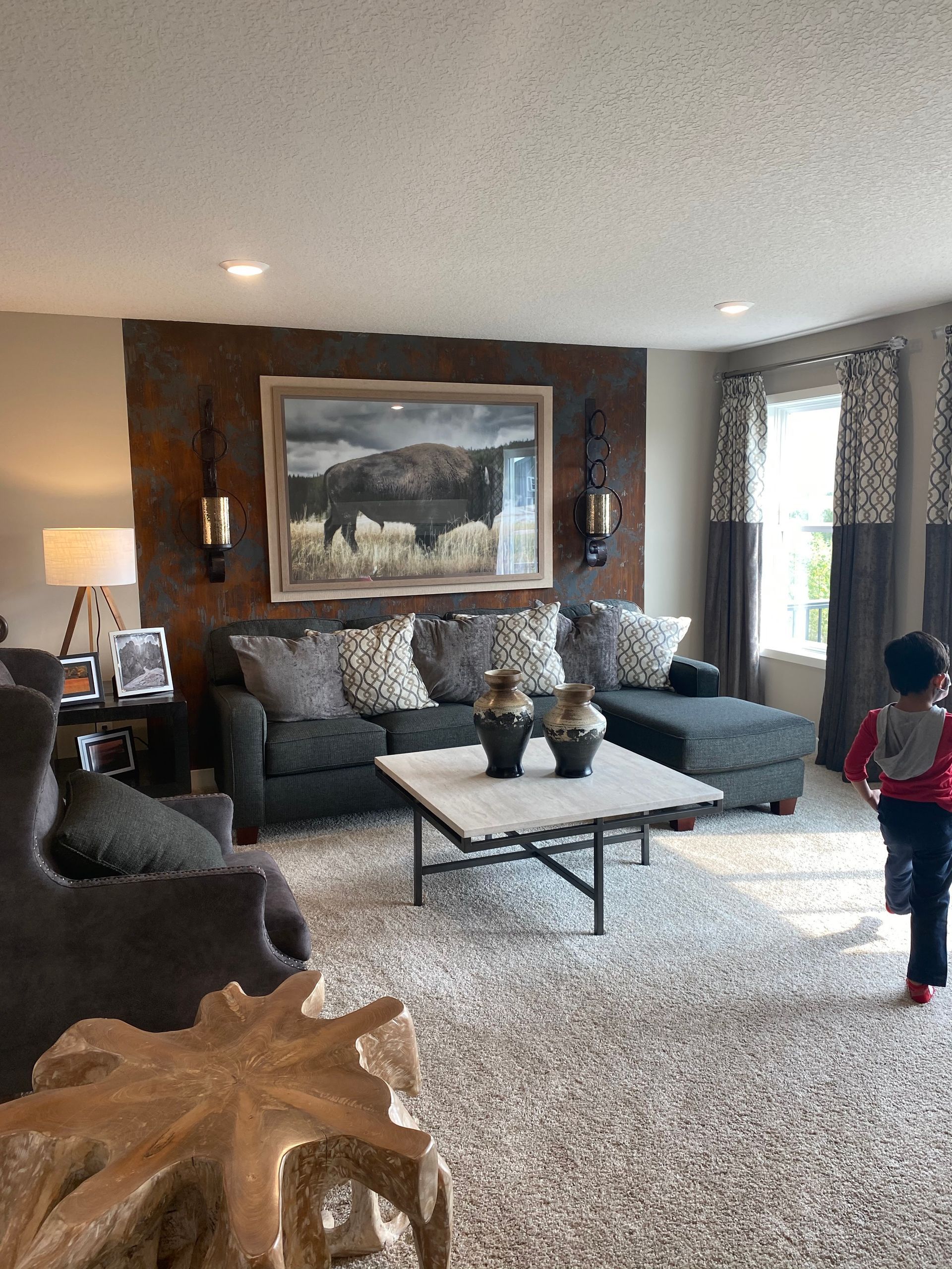 A living room with a couch , chairs , coffee table and a painting on the wall.