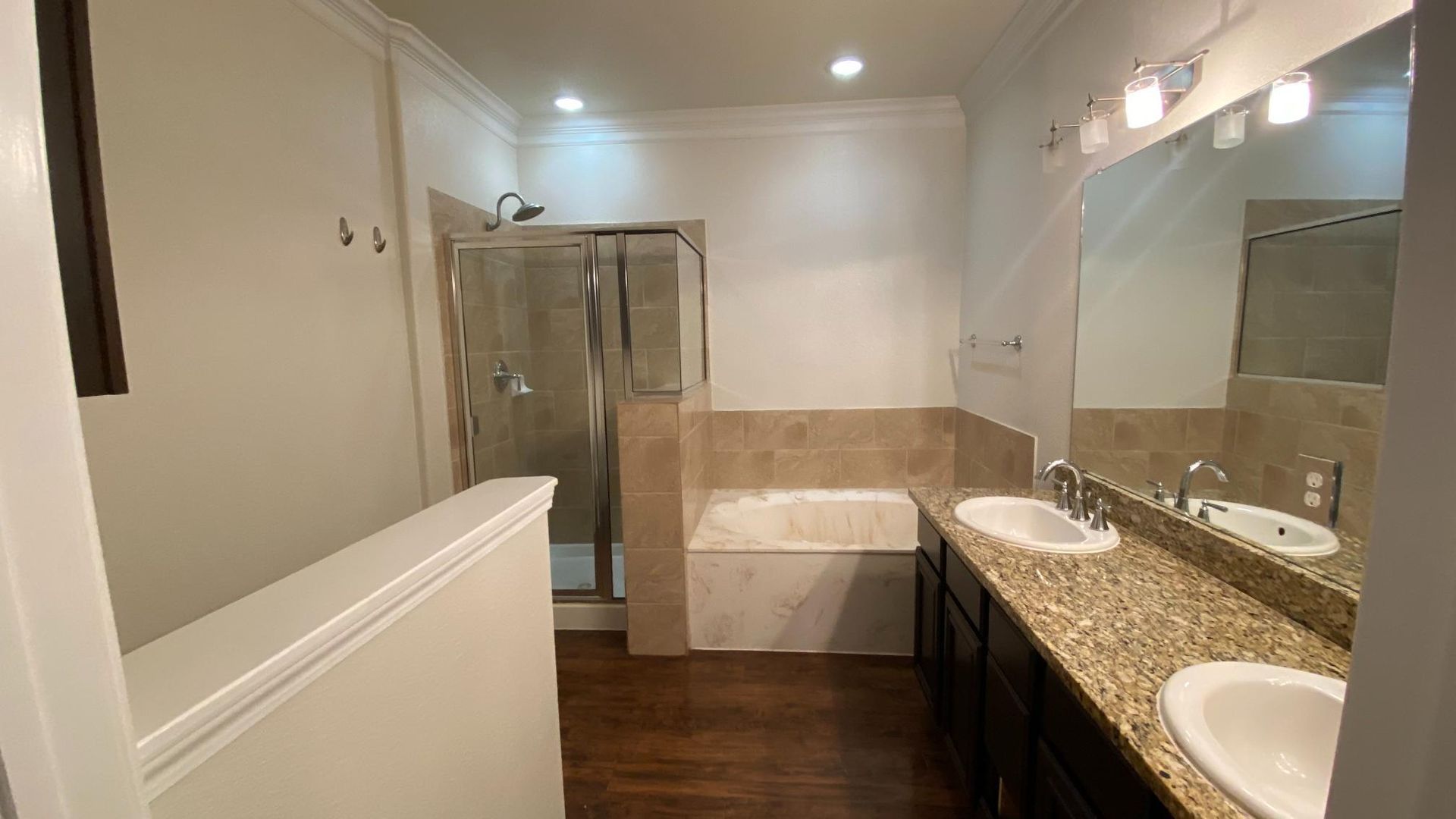 A bathroom with two sinks , a tub and a shower.