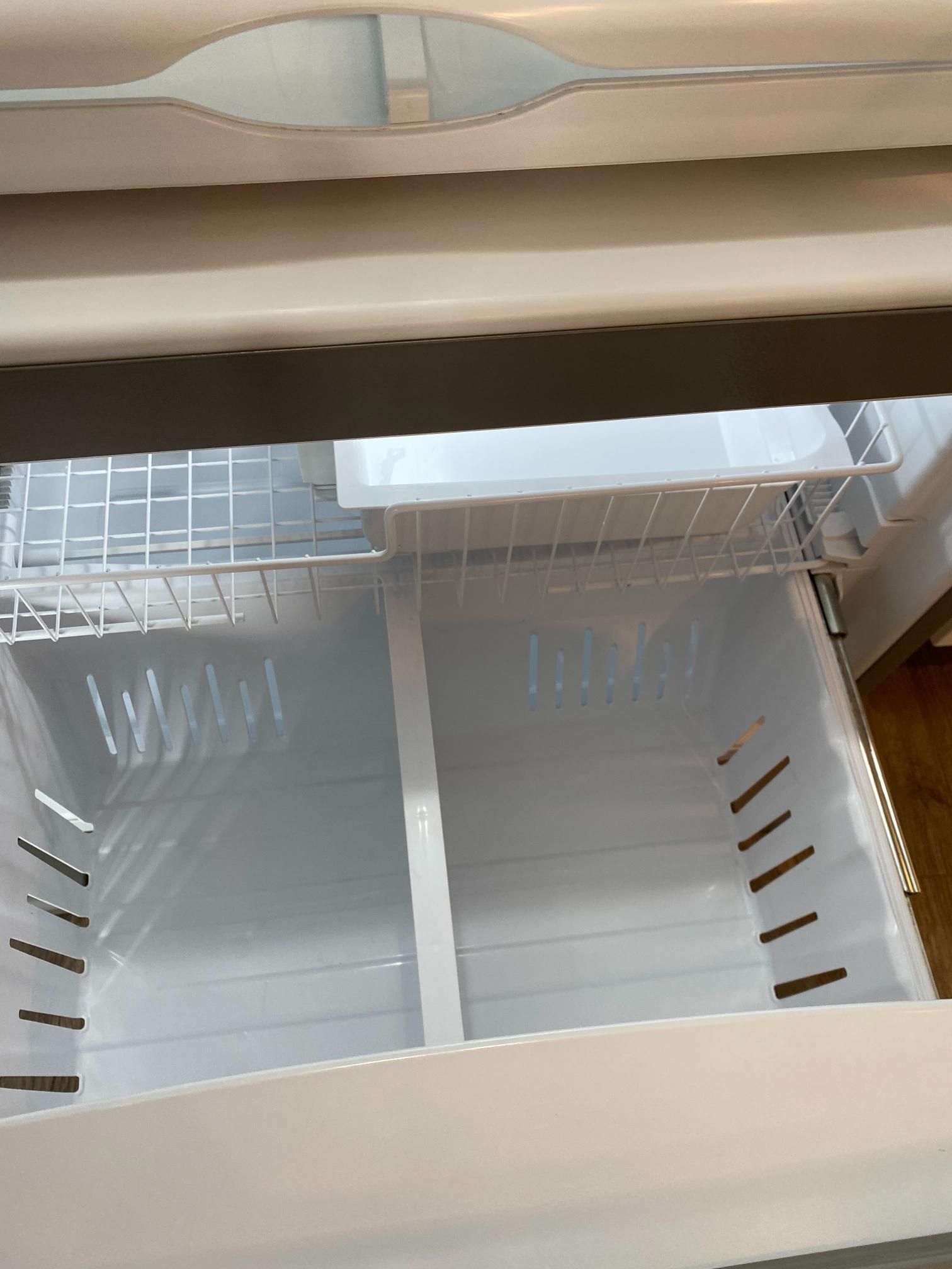 The inside of an empty refrigerator with a shelf and a drawer.