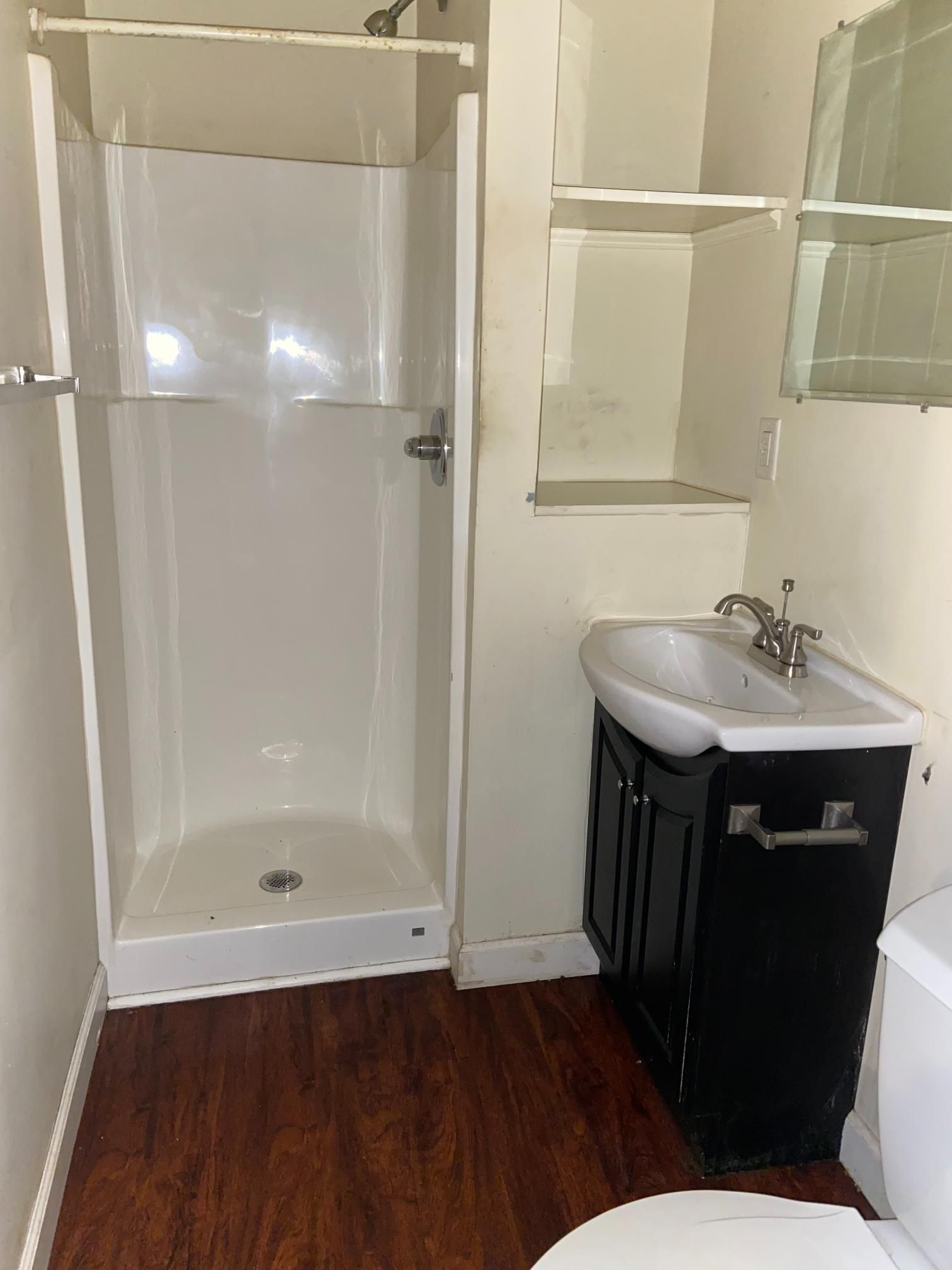 A bathroom with a toilet , sink and shower.