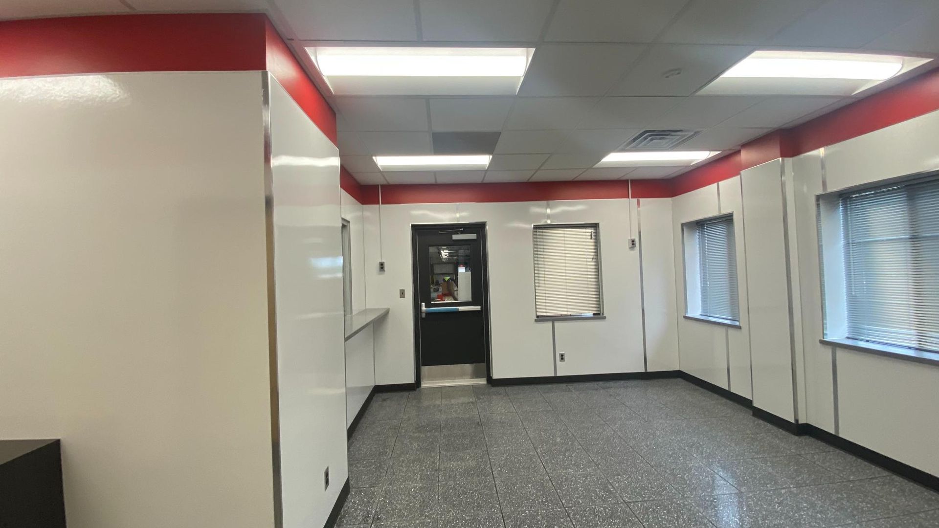 An empty room with white walls and red trim