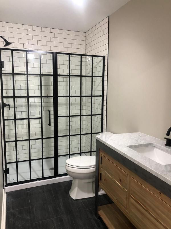 A bathroom with a toilet , sink and shower stall.