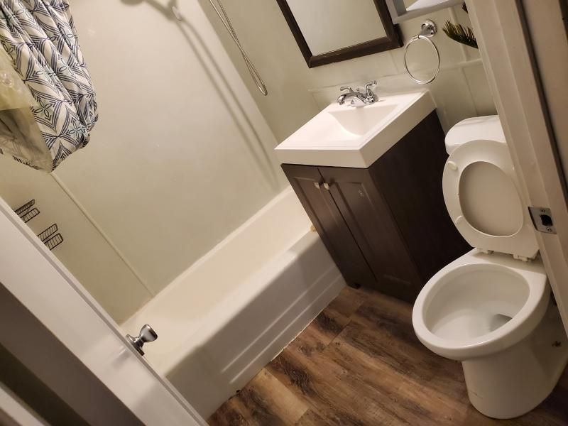 A bathroom with a toilet , sink and bathtub.